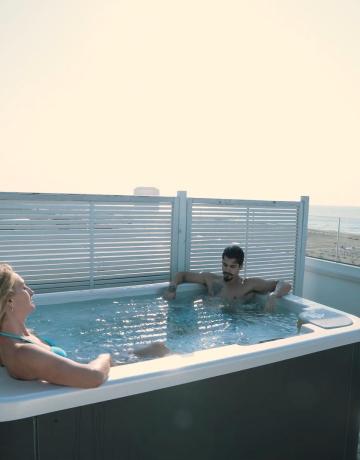 Two people in a hot tub with sea view.