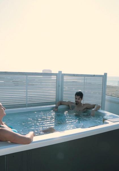 Two people in a hot tub with sea view.