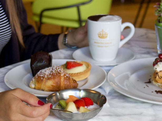 Frühstück mit Gebäck und Obst auf Marmortisch.