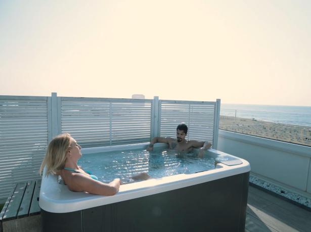 Zwei Personen im Whirlpool mit Meerblick.