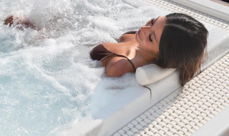 Woman relaxing in an outdoor hot tub.