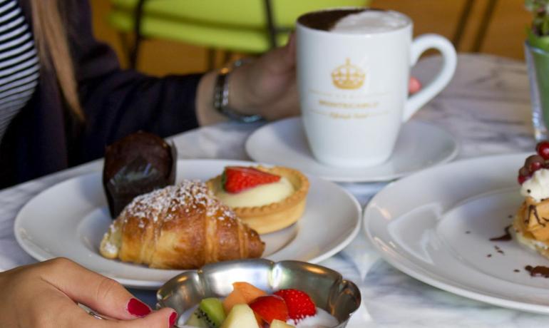 Breakfast with pastries and fruit on a marble table.