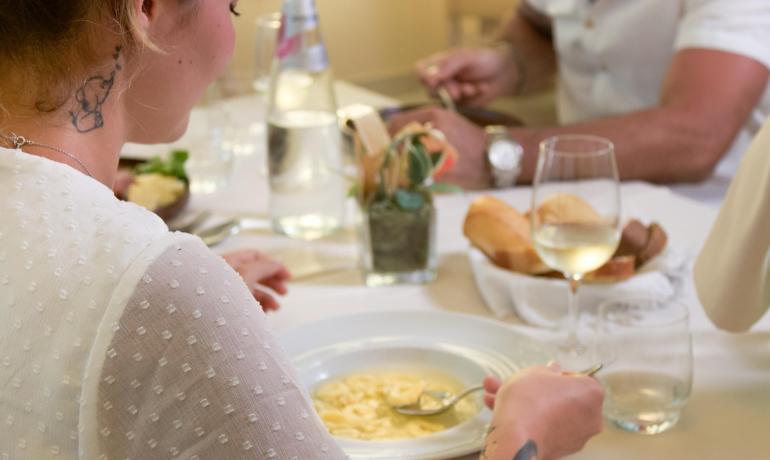 Elegant dinner with tortellini and white wine, refined atmosphere.